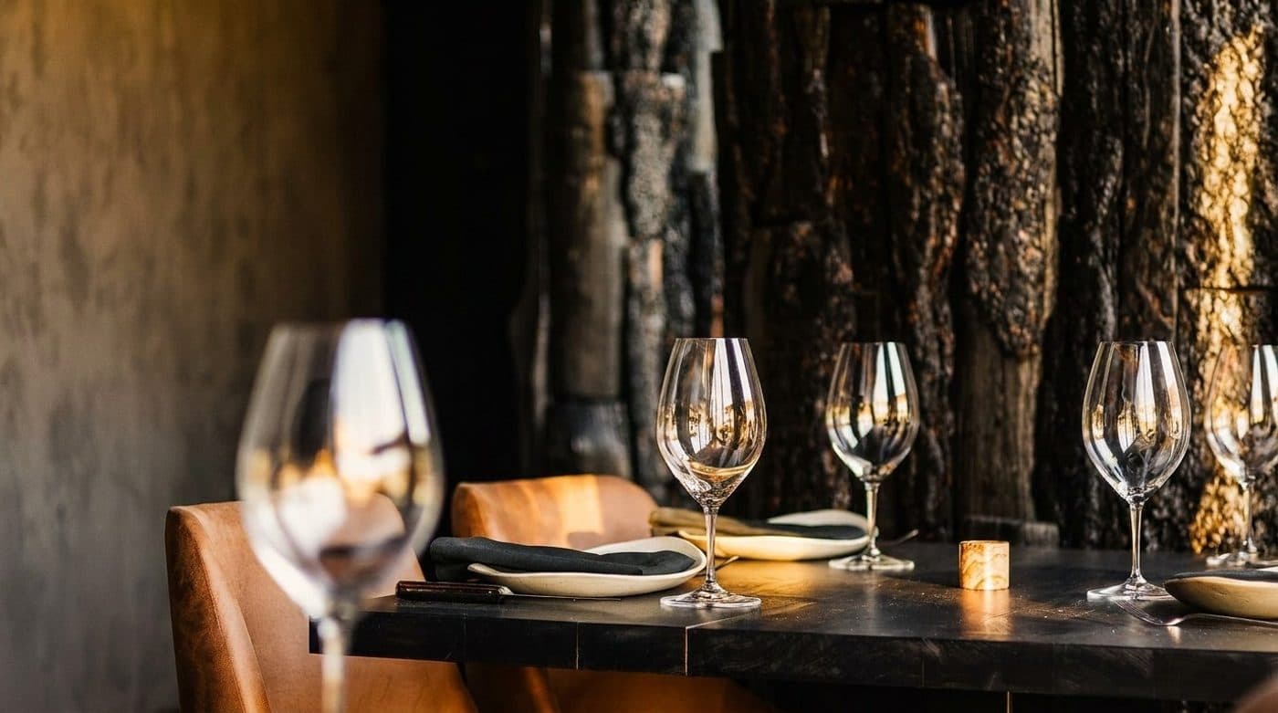 An intimate Origen table set with wine glasses